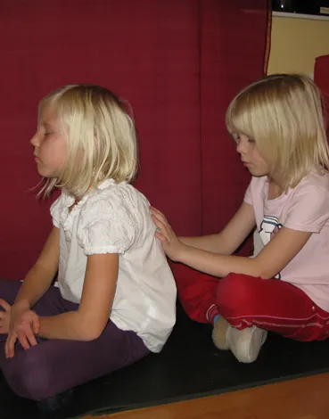 Ett barn ger ett annat barn massage på ryggen