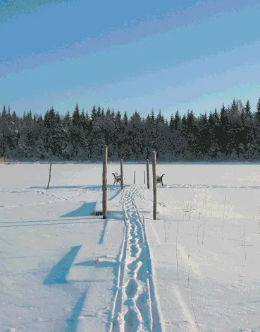 Snötäckt sjö med spår ut mot bryggan en vinterdag