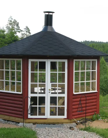 Röd åttakantig grillstuga med stora fönster