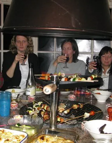 Gäster kring grillen inne i grillstugan