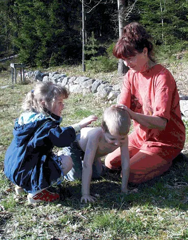Barn som masserar varandra utomhus med en kursledare