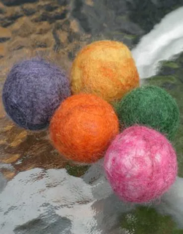Tovade ullbollar i lila, orange, grönt och rosa