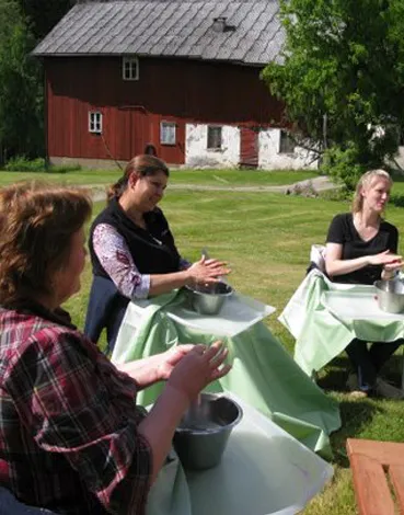 Deltagare som arbetar med skålar vid ett bord i trädgården